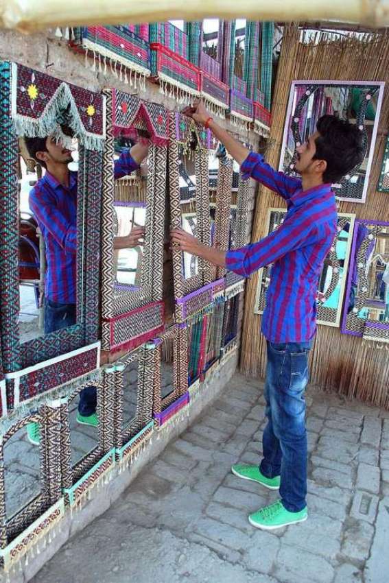 فیصل آباد: ایک نوجوان دکاندار فروخت کے لیے فینسی آئینہ سجا ..