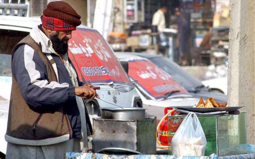 راولپنڈی: ایک محنت کش سڑک کنارے سٹال لگائے گاہکوں کے لیے ..