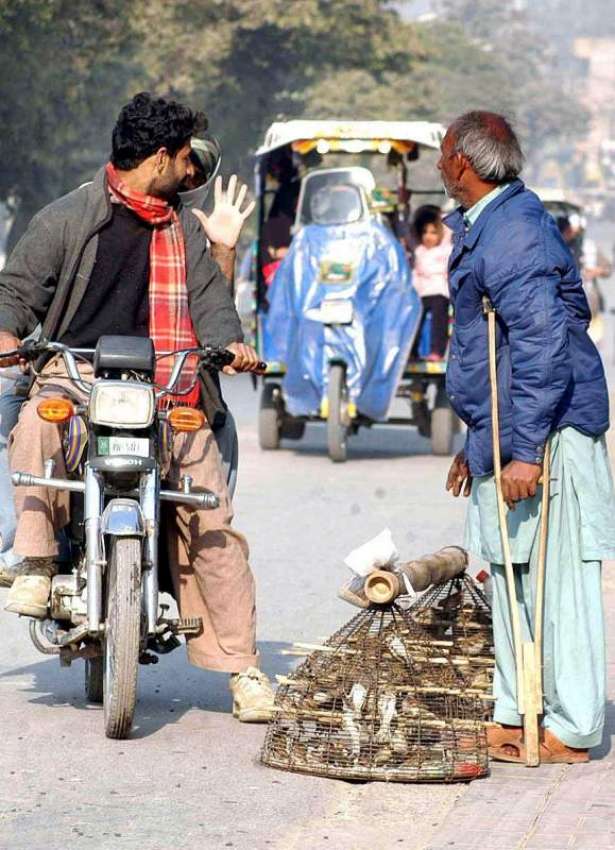 راولپنڈی: ایک معذور محنت کش سڑک کنارے پرندے فروخت کر رہا ..