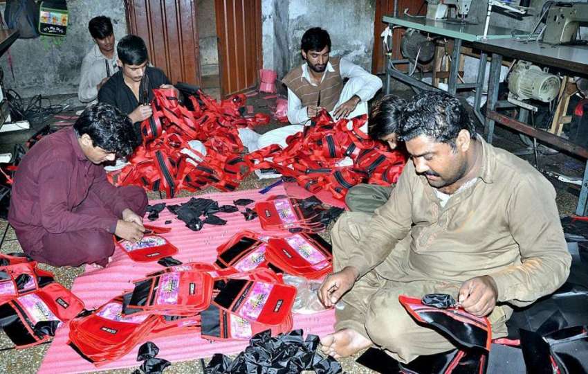 لاہور: محنت کش سکول بیگ بنانے میں مصروف ہیں۔