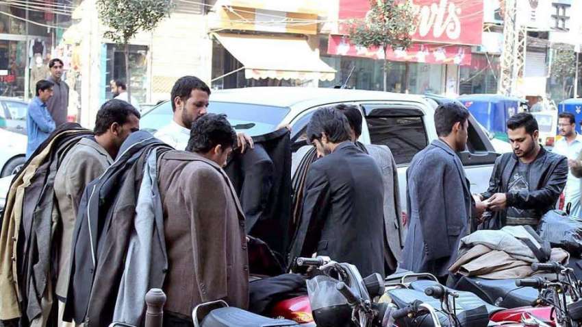 پشاور: دو محنت کش پھیری لگا کر کوٹ فروخت کر رہے ہیں۔