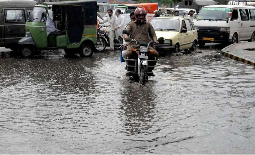 راولپنڈی: موسلا دھار بارش کے بعد ایک موٹر سائیکل سوار بارش ..