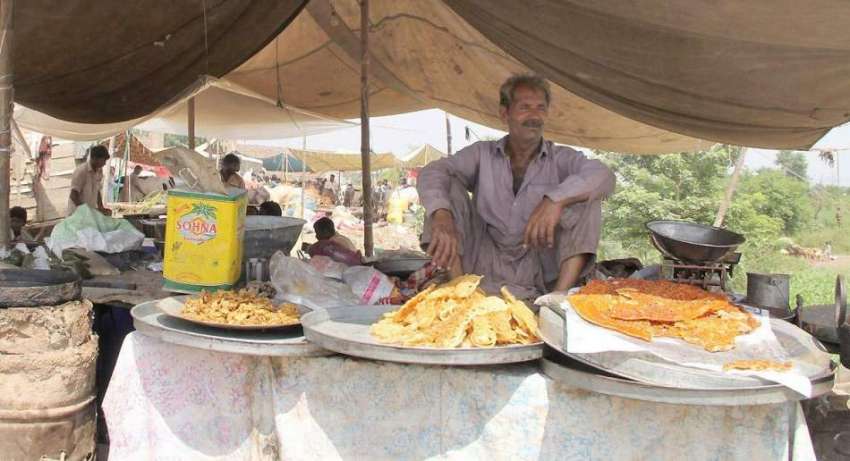 لاہور: مویشی منڈی میں ایک شخص نے کھانے پینے کی اشیاء کا سٹال ..
