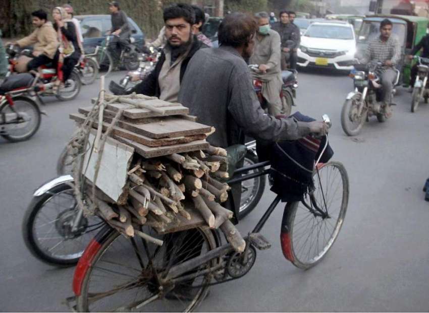 لاہور: ایک شخص گھر کا چولہا جلانے کے لیے لکڑیاں سائیکل پر ..