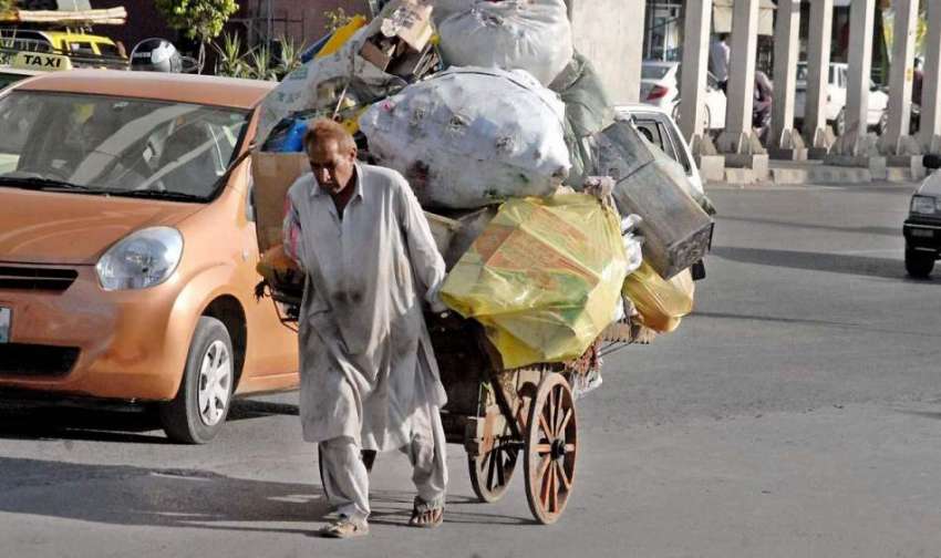 راولپنڈی: ایک محنت کش سامان سے لدھا ہتھ ریڑھا کھینچتے ہوئے ..