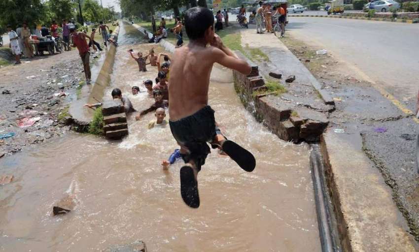 فیصل آباد: گرمی کی شدت کم کرنے کے لیے بچے راجباہ میں نہا رہے ..