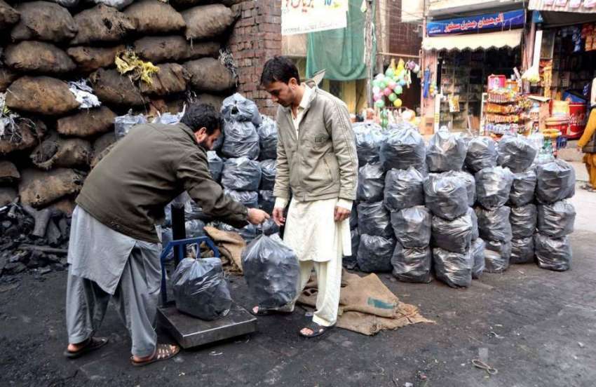 لاہور: ایک شہری ٹال سے کوئلے خرید رہا ہے۔