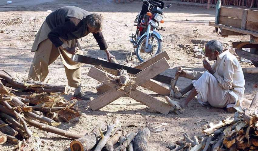 فیصل آباد: معمر محنت کش لکڑیاں کاٹنے میں مصروف ہیں۔