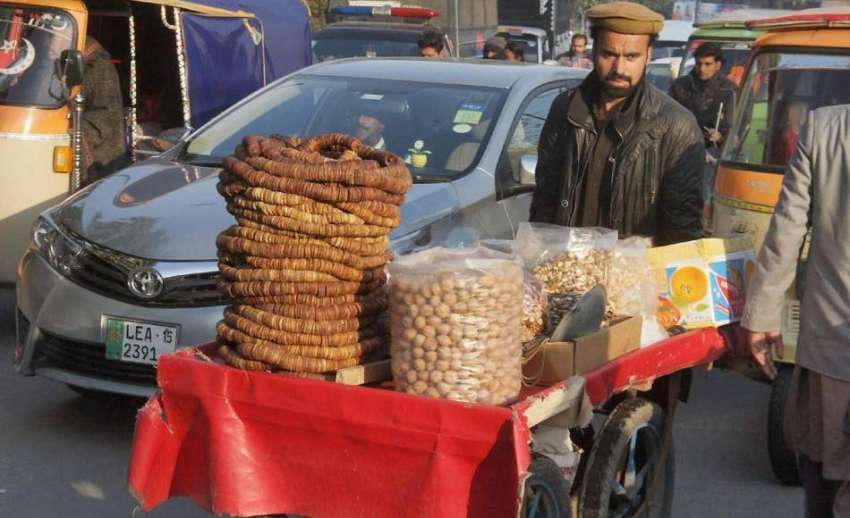 لاہور: ایک شخص ریڑھی پر خشک میوہ جات فروخت کر رہا ہے۔