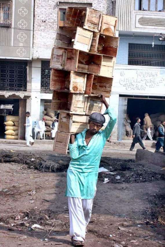 حیدر آباد: ایک مزدور فروٹ کی خالی پیٹیاں اٹھائے لیجا رہا ..