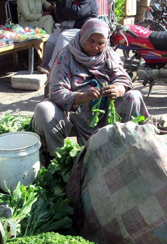 فیصل آباد: ایک معمر خاتون تازہ سبزی فروخت کر رہی ہے۔
