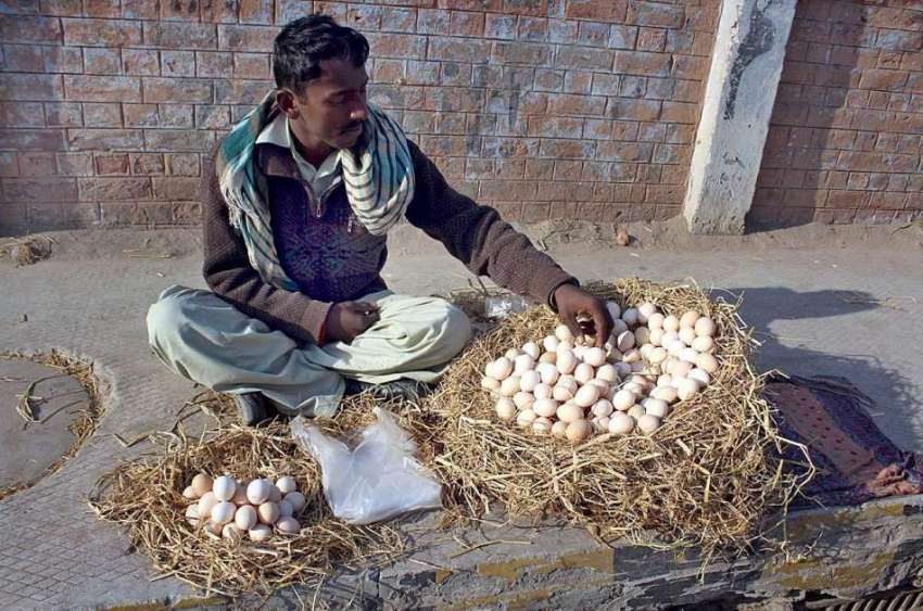 ملتان: محنت کش سڑک کنارے بیٹھا انڈے فروخت کر رہا ہے۔