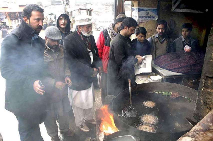 ایبٹ آباد: کبابوں کی دکان پر شہری خود کو گرم رکھنے کے لیے ..