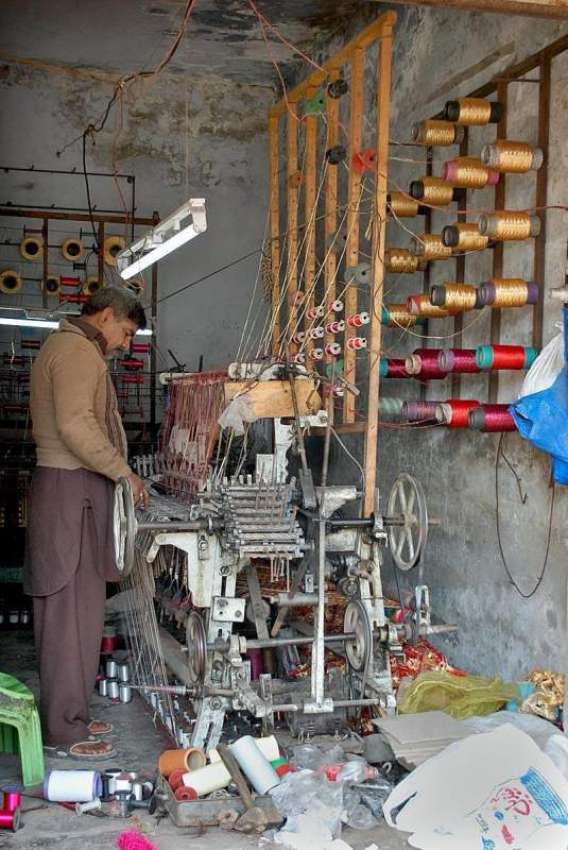 فیصل آباد: مزدور لوم پر کام میں مصروف ہے۔