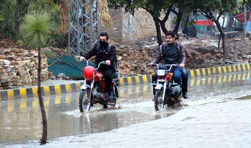 راولپنڈی: دو موٹر سائیکل سوار بارش کے دوران اپنی منزل کی ..