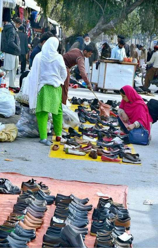 اسلام آباد: سڑک کنارے لگے سٹال سے خواتین جوتے پسند کر رہی ..