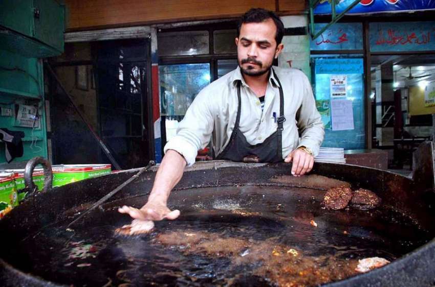 پشاور: ایک دکاندار کباب فرائی کر رہا ہے۔