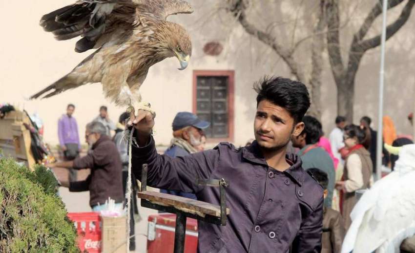  لاہور: بادشاہی مسجد کے گیٹ پر ایک نوجوان عقاب کو اپنے ہاتھ ..
