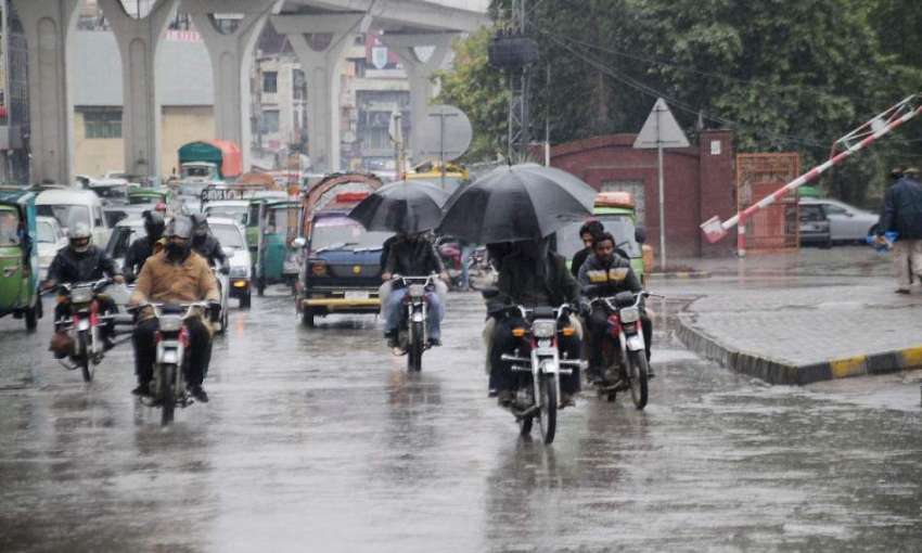 راولپنڈی: بارش سے بچنے کے لیے موٹر سائیکل سوار چھتری تانے ..