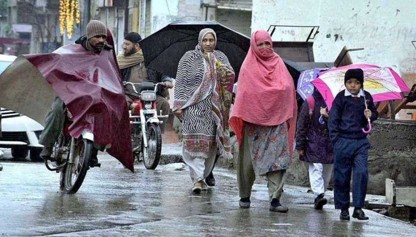 راولپنڈی: بارش سے بچنے کے لیے شہری چھتری تانے جا رہے ہیں۔