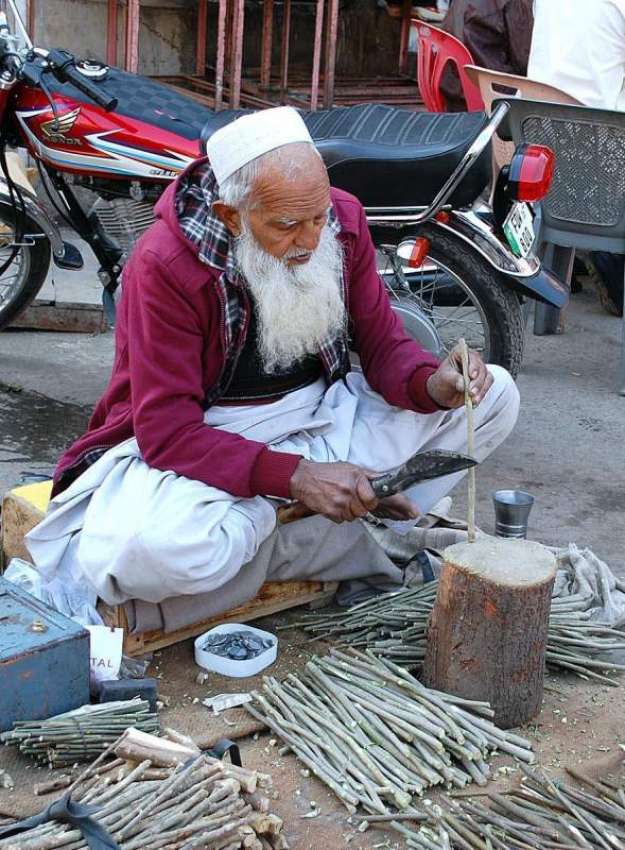 فیصل آباد: ایک معمر شخص فروخت کے لیے مسواکیں تیار کر رہا ..