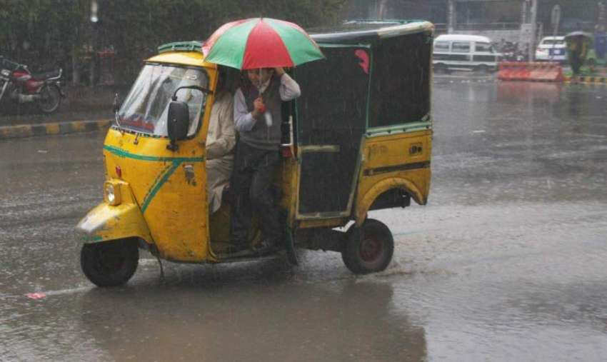 لاہور: شہر میں ہونے والی بارش کے دوران ایک طالبعلم رکشے میں ..