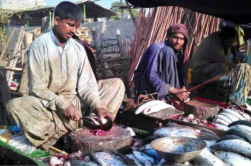 کراچی: مچھلی فروش سڑک کنارے مچھلی کا سٹال لگائے بیٹھے ہیں۔