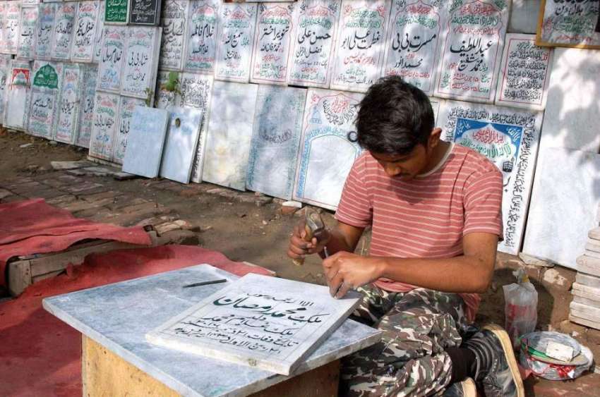 فیصل آباد: ایک محنت کش پتھر تراش کر نام لکھ رہا ہے۔