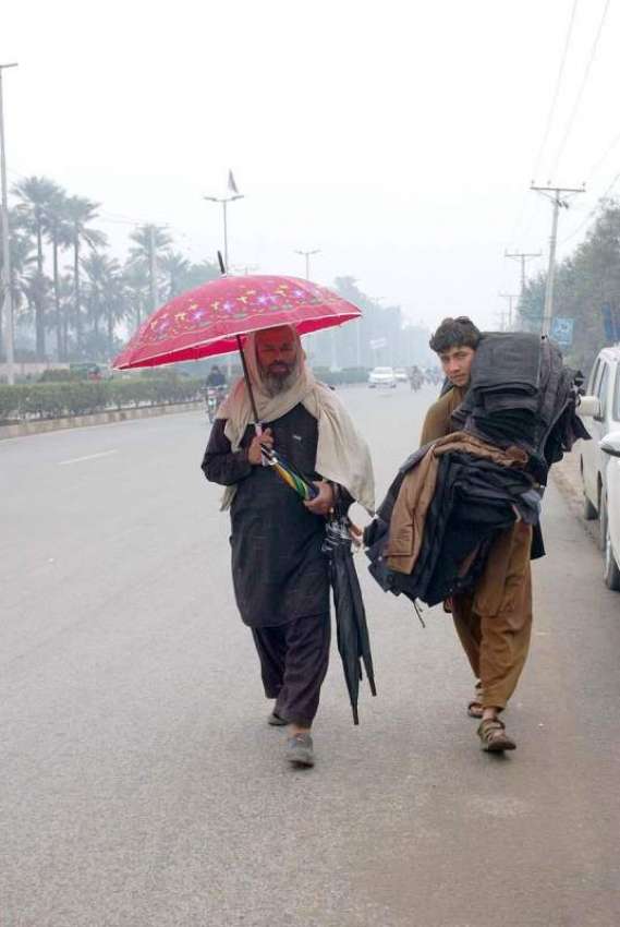 فیصل آباد: دو محنت کش پھیر لگا کر جیکٹیں اور چھتریاں فروخت ..