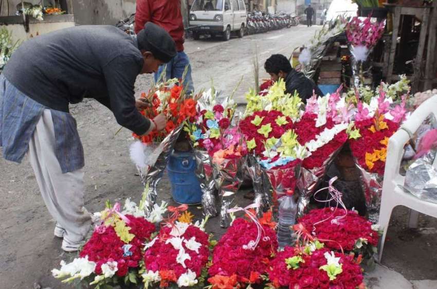 لاہور: ایک دکاندار پھولوں کے گلدستے بنائے فروخت کر رہا ہے۔