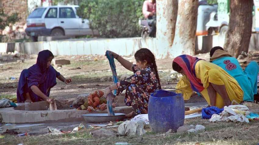حیدر آباد: خانہ بدوش خواتین سڑک کناری بیٹھی کپڑے دو رہی ہیں۔