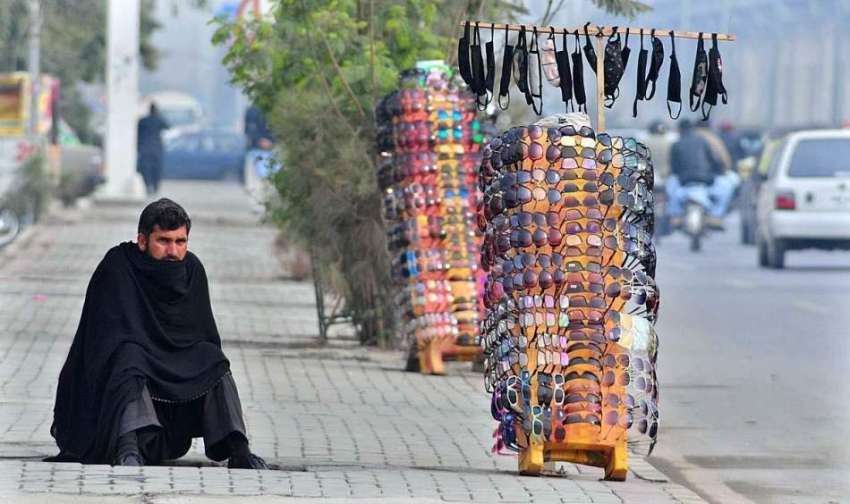 راولپنڈی: ایک محنت کش سڑک کنارے عینکوں کا سٹال لگائے گاہکوں ..