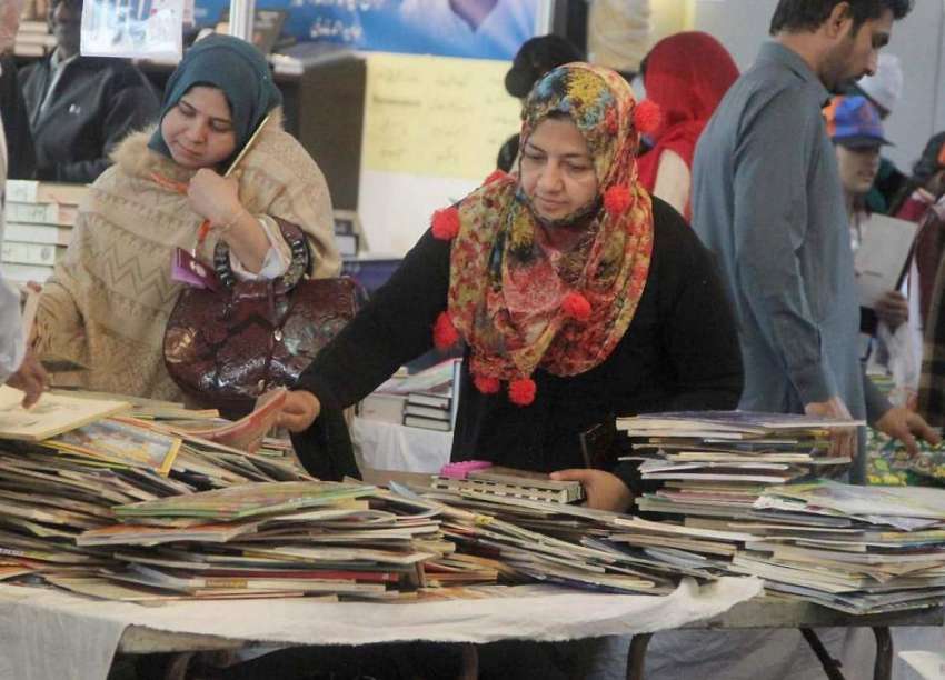 لاہور: ایکسپو سنٹر میں ایک خاتون سٹال سے کتابیں دیکھ رہی ..