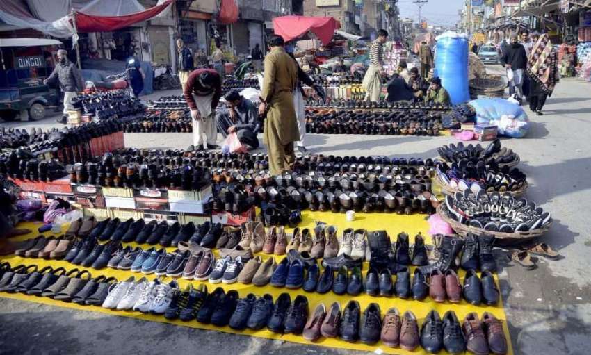 راولپنڈی: ایک دکاندار نے سڑک کنارے فروخت کے لیے جوتے سجا ..