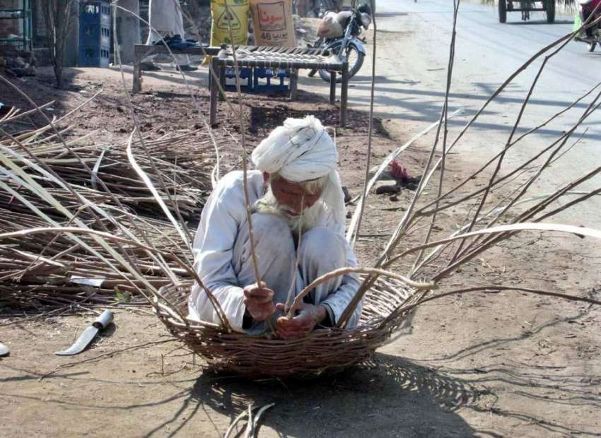 فیصل آباد: ایک معمر محنت کش ٹہنیوں کی مدد سے ٹوکری بنانے ..