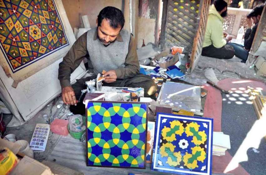 لاہور: ایک آرٹس مسجد وزیر خان میں لگانے کے لیے ٹائلیں کاٹ ..