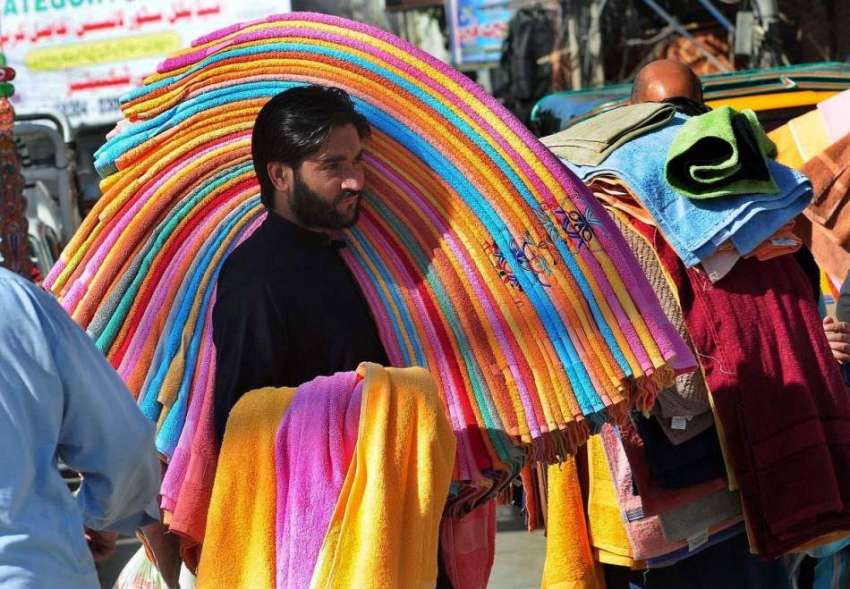 راولپنڈی: ایک محنت کش کندھوں پر تولیے رکھے پھیری لگا کر فروخت ..