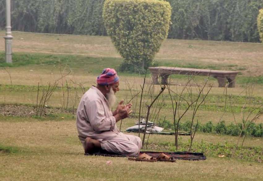 لاہور: باغ جناح میں ایک بزرگ شہری نماز ادا کرنے کے بعد دعا ..