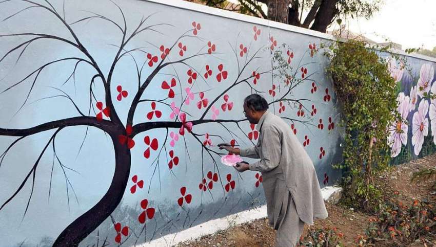 لاہور: جشن بہاراں کے سلسلہ میں ایک پینٹر دیوار پر پینٹنگ ..