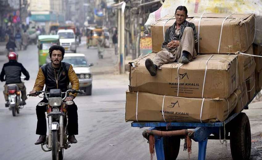 راولپنڈی: ایک محنت کش اپنی ہتھ ریڑھی پر رکھے سامان پر بیٹھا ..