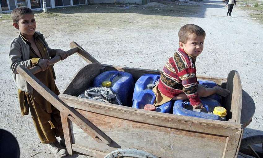 راولپنڈی: خانہ بدوش بچے ہتھ ریڑھی پر خالی کین رکھے واٹر فلٹریشن ..