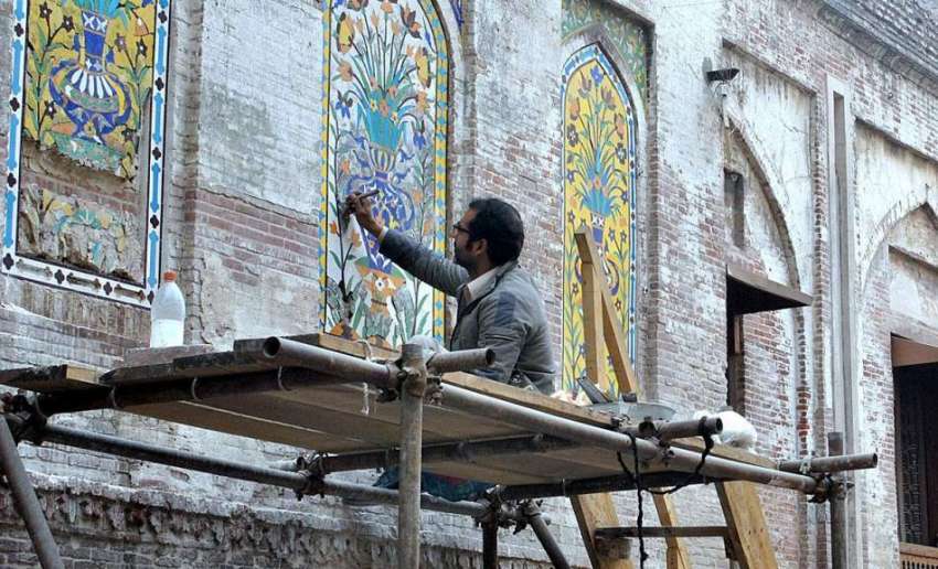 لاہور: مزدور مسجد وزیر خان کی دیوار کی آرائش میں مصروف ہے۔