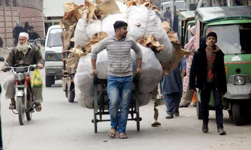 لاہور: ایک شخص ہتھ ریڑھی پر ردی کی گانٹھ رکھے جا رہا ہے۔