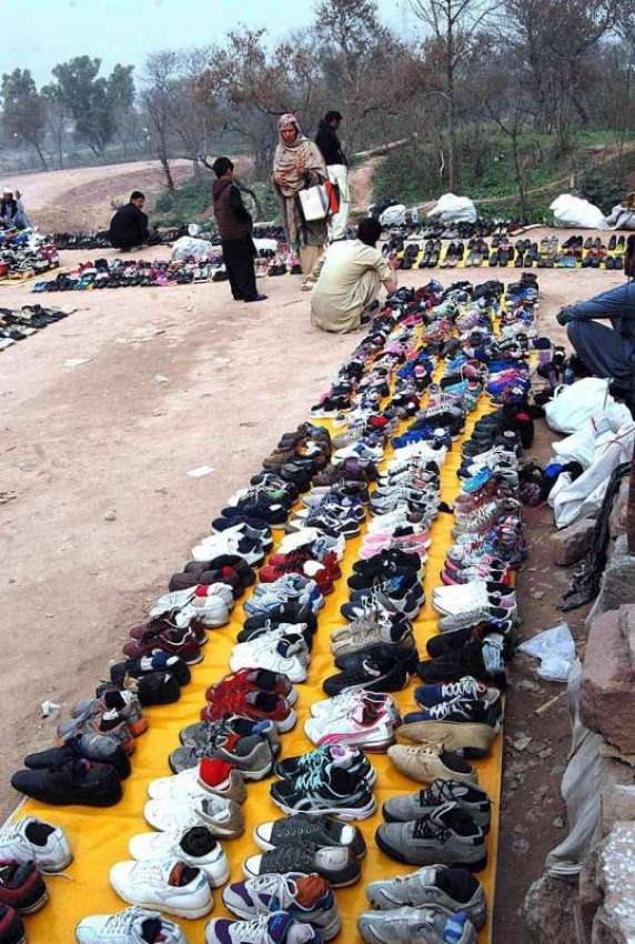 اسلام آباد: ایک دکاندار نے سڑک کنارے فروخت کے لیے جوتے لگا ..