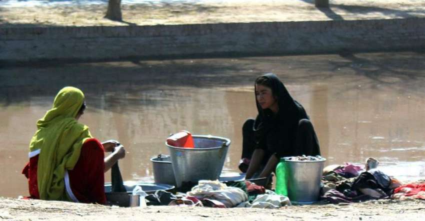 ملتان: خانہ بدوش خواتین نوبہار کینال پر کپڑے دھو رہی ہیں۔