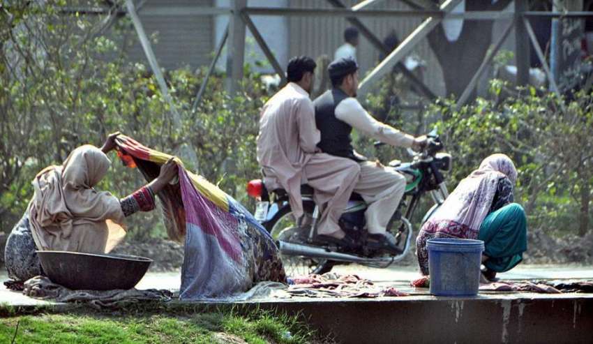 لاہور: خانہ بدوش خواتین نہر کنارے کپڑے دھو رہی ہیں۔