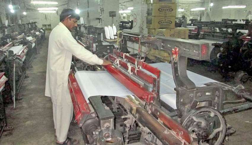 فیصل آباد: ایک مزدو پاور لوم پر کام میں مصروف ہے۔