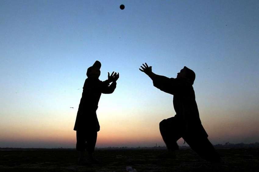 لاہور: کھیل کود میں مصروف دو نوجوان گیند کو کیچ کرنے کی کوشش ..