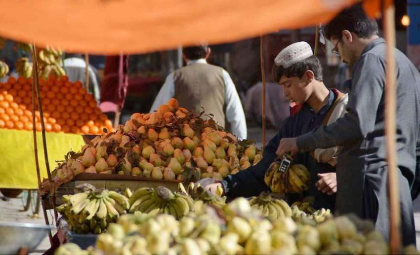 کوئٹہ: علمدار روڈ پر ایک شہری ریڑھی بان سے فروٹ خرید رہا ..