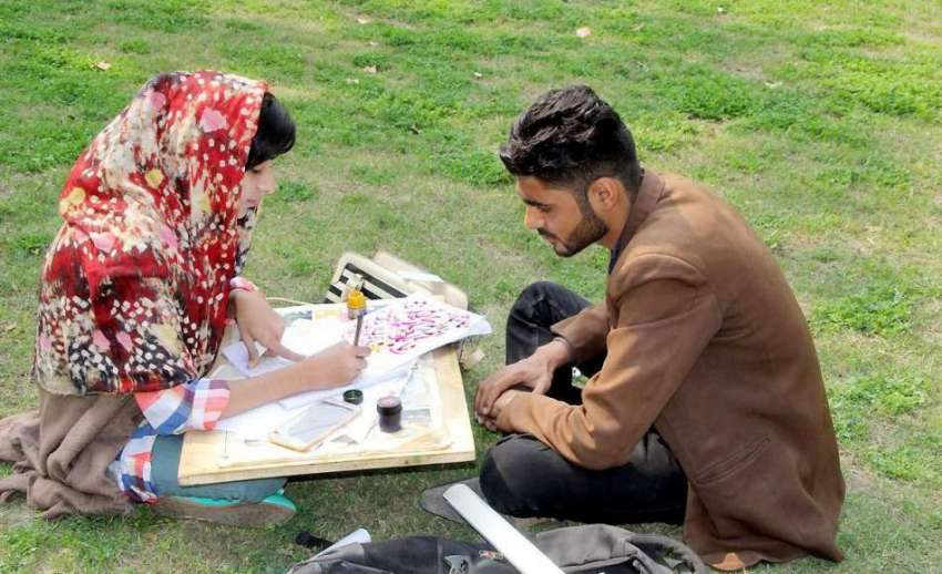 لاہور:الحمراء ہال کے صحت میں بیٹھی ایک طالبہ خطاطی کی مشق ..